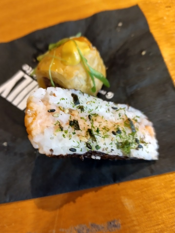 Spicy salmon musubi, sprinkled with seaweed and sesame.