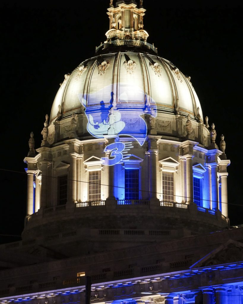 Sonic the Hedgehog 3 projections featuring images of Sonic, Shadow, and the classic Robotnik icon appear in multiple cities and locations around the world, as seen here at City Hall, San Francisco.